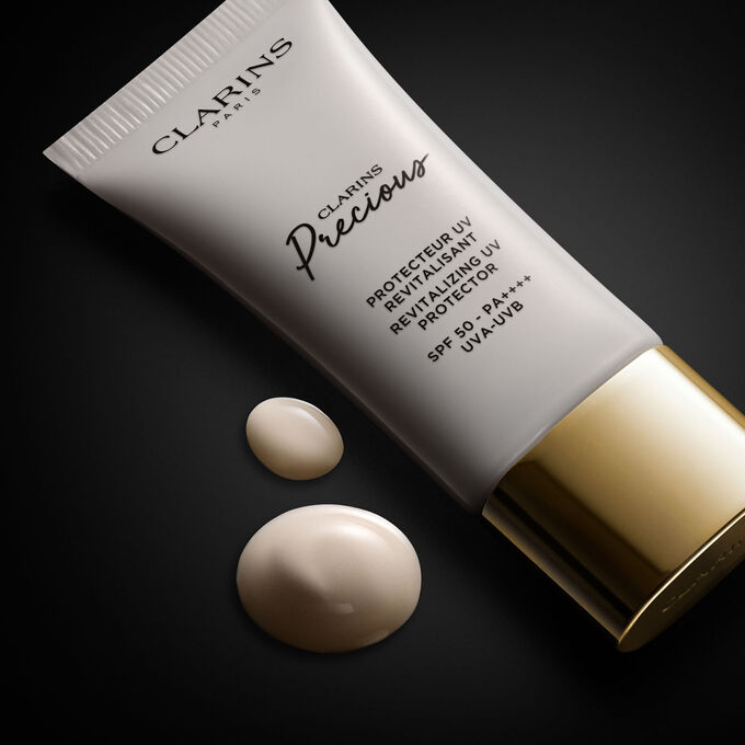 Clarins anti-aging UV Protection tube, showcased on a black background, accompanied by text detailing its function and skincare effects